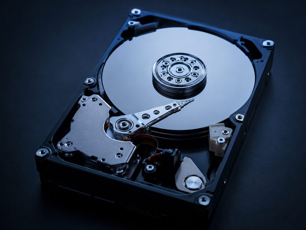 Internal hard drive with its cover removed, exposing the platter and head